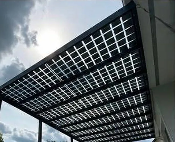 Gros plan sur la toiture vue de dessous : cellules monocristallines espacées dans le verre, chevrons anthracite.