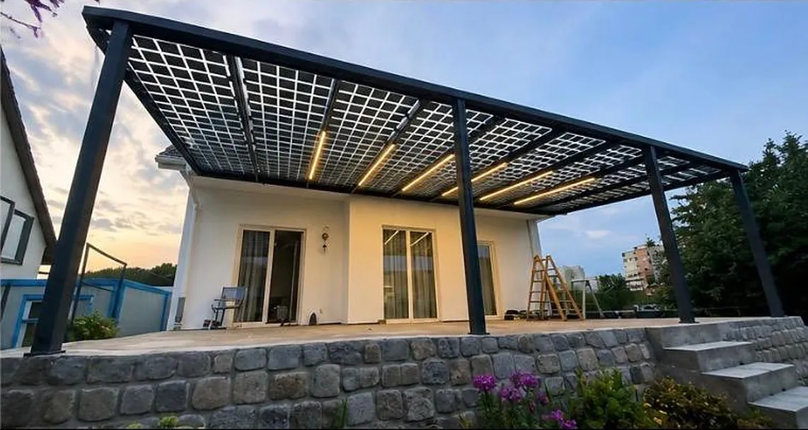 Pergola en verre solaire à la tombée du jour, rubans LED allumés sous les chevrons.
